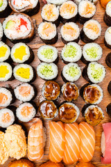 big set of sushi and rolls on wooden table