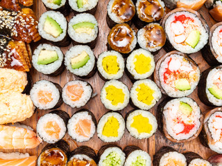 assortment of sushi and rolls on wooden table