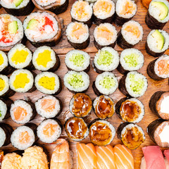 different sushi and rolls on wooden table