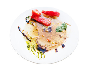 white plate with leftover vegetables and sauces