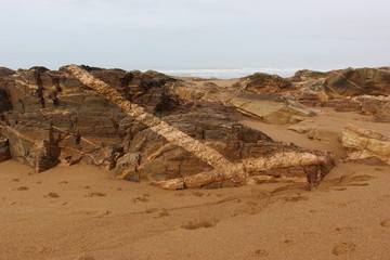 Fototapeta na wymiar Rochers zébrés sur la plage de l'anse de Chaillé près des Sables-d'Olonne (Vendée)