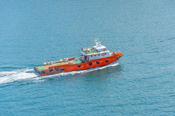 Small tug ship sails in a harbor bay in the mediterranean sea.