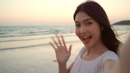 Blogger Asian woman record vlog video on beach, young beautiful female happy using mobile phone make vlog video on beach near sea when sunset in evening. Lifestyle women travel on beach concept.