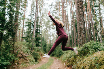 Sportive woman jumping in forest