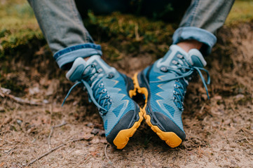 Male legs wearing sportive hiking shoes outdoor. Mens legs in trekking boots for outdoor activity