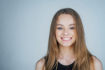 Obraz premium Headshot Portrait of happy girl with beauty face smiling looking at camera. Pretty smiling joyfully female with fair hair - dressed casually.