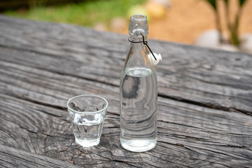 Bottle and glass with water on the wooden table