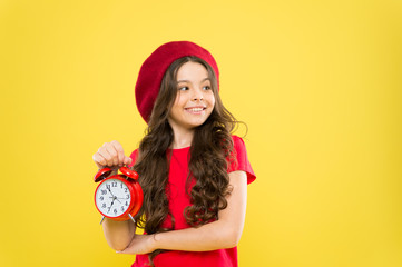 Everything is under control. Define own rhythm of life. Schedule and time. Set up alarm clock. Child little girl hold red clock. Always on time. It is never too late. Controlling personal time