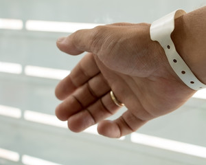 Male hand with newborn birth tag