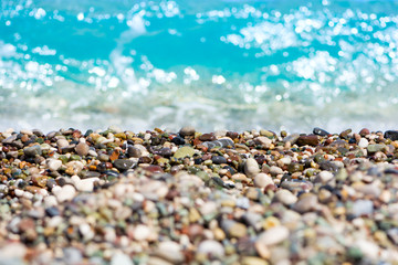 Pebble beach with sea waves. Travel concept. Selective focus