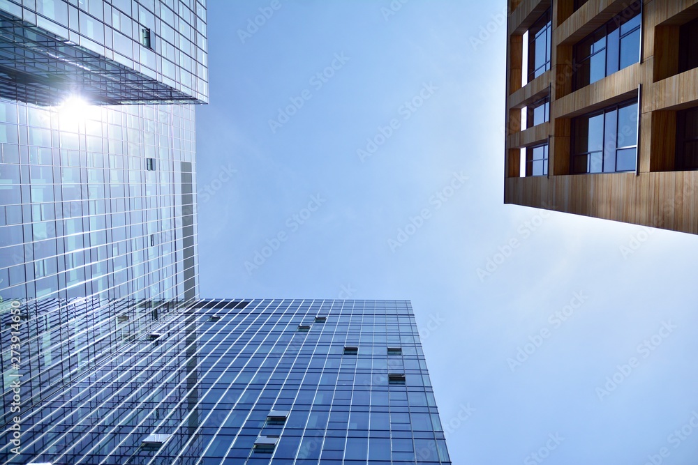 Wall mural bottom view of modern skyscrapers in business district against blue sky