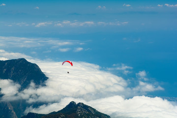 Paragliding flying in the sky over mountains and sea. Aerial view from Tahtali mountain, Turkey....