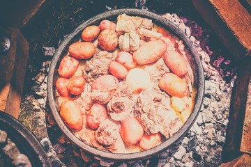 Cooking meat of lamb and vegetables in nature, traditional Serbian dish 