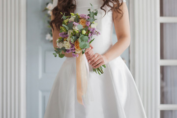 Elegant bride in a white dress with a wedding bouquet