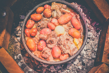 Cooking meat of lamb and vegetables in nature, traditional Serbian dish 