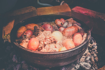 Cooking meat of lamb and vegetables in nature, traditional Serbian dish 