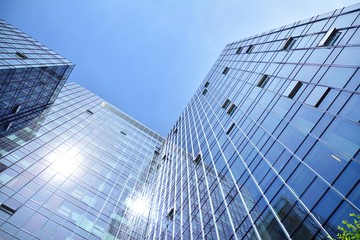 Obraz na płótnie Canvas Bottom view of modern skyscrapers in business district against blue sky