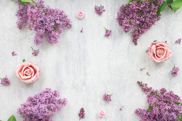 Pink rose and lilac flowers on grey background, flat lay, top view
