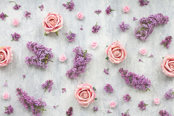 Pink rose and lilac flowers on grey background, flat lay, top view