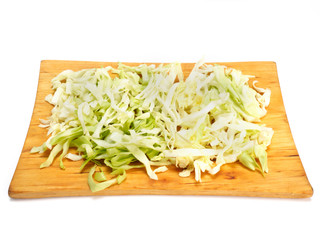 Chopped green cabbage on cutting board, white background with copy space