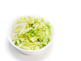 Chopped green cabbage in white bowl on a white background with copy space