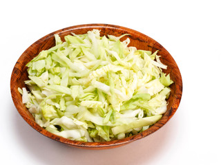 Chopped green cabbage in a bamboo bowl on a white background