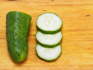Chopped green cucumber on wooden background