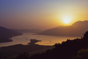 Obraz premium Sunset behind the mountains against the backdrop of the sea