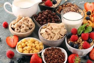 Cereal. Bowls of various cereals, berries and milk for breakfast. Muesli with kids cereals.
