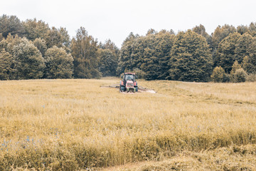Tractor mows the grass. harvesting hay for the winter