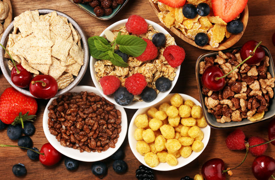 Cereal. Bowls of various cereals, berries and milk for breakfast. Muesli with kids cereals.