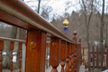 Wooden brown carved railing of the bridge leading to the church