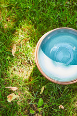 top view of blue empty ceramic bowl on green grass