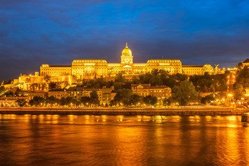 Fototapeta na wymiar Buda Castle by the Danube river, illuminated at dusk