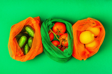 Fresh fruits and vegetables in reusable textile mesh bags.