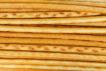 Salty or sweet straw from dough, snack from crackers, crispy breadsticks, close-up background