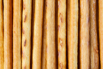 Salty or sweet straw from dough, snack from crackers, crispy breadsticks, close-up background