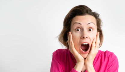 Image of an excited screaming young woman standing in a pink blouse isolated over a light background.