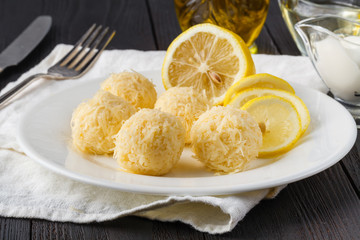 Small cheese balls on a plate. Cream cheese balls with dried herbs and roasted sesame seeds