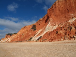 Red high cliffs at Praia da Falesia, a paradise beach in Albufeira in Portugal