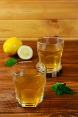 Kombucha tea with lemon, ice and mint on a wooden table. Probiotic food.