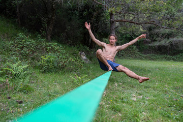 Athletic male exercises on balance beam
