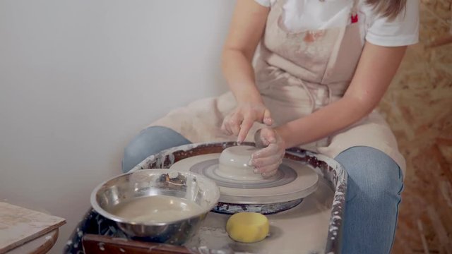 Female potter creating a ceramics clay vase.