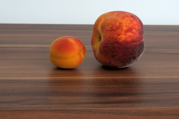 Red apricot and red peach on a brown wooden table background. Space for text.