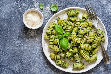 Pasta with pesto and parmesan on a concrete background. View from above.