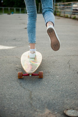 Girl with longboard wearing sneakers shoes in urban style