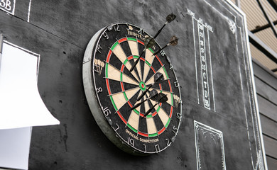 .area for playing darts with a sheet of glasses on a black background. Darts and darts scoreboards