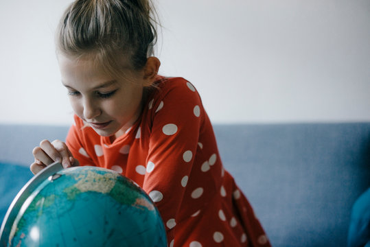 Girl at home looking at globe