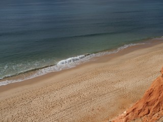 Red high cliffs at Praia da Falesia, a paradise beach in Albufeira in Portugal