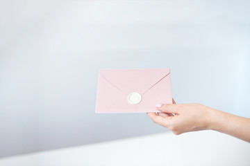 Obraz premium Close-up woman with slim body holding in hands the invitation card blue pink color square shape envelope card